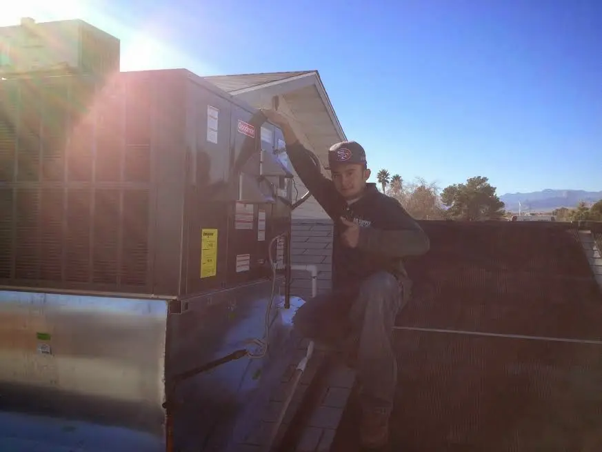 HVAC technician performing Air Duct Repair on a rooftop unit in Commerce